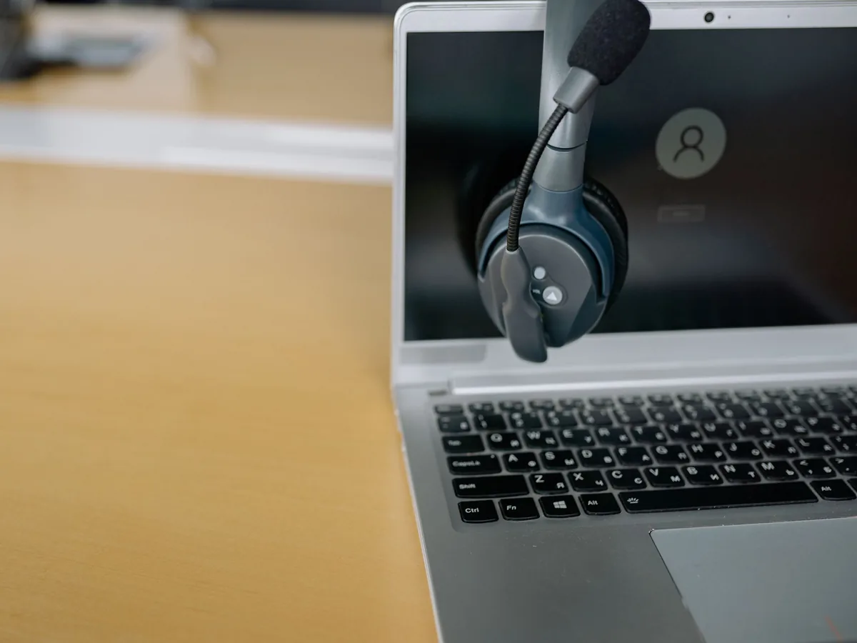A headset hanging on an open laptop